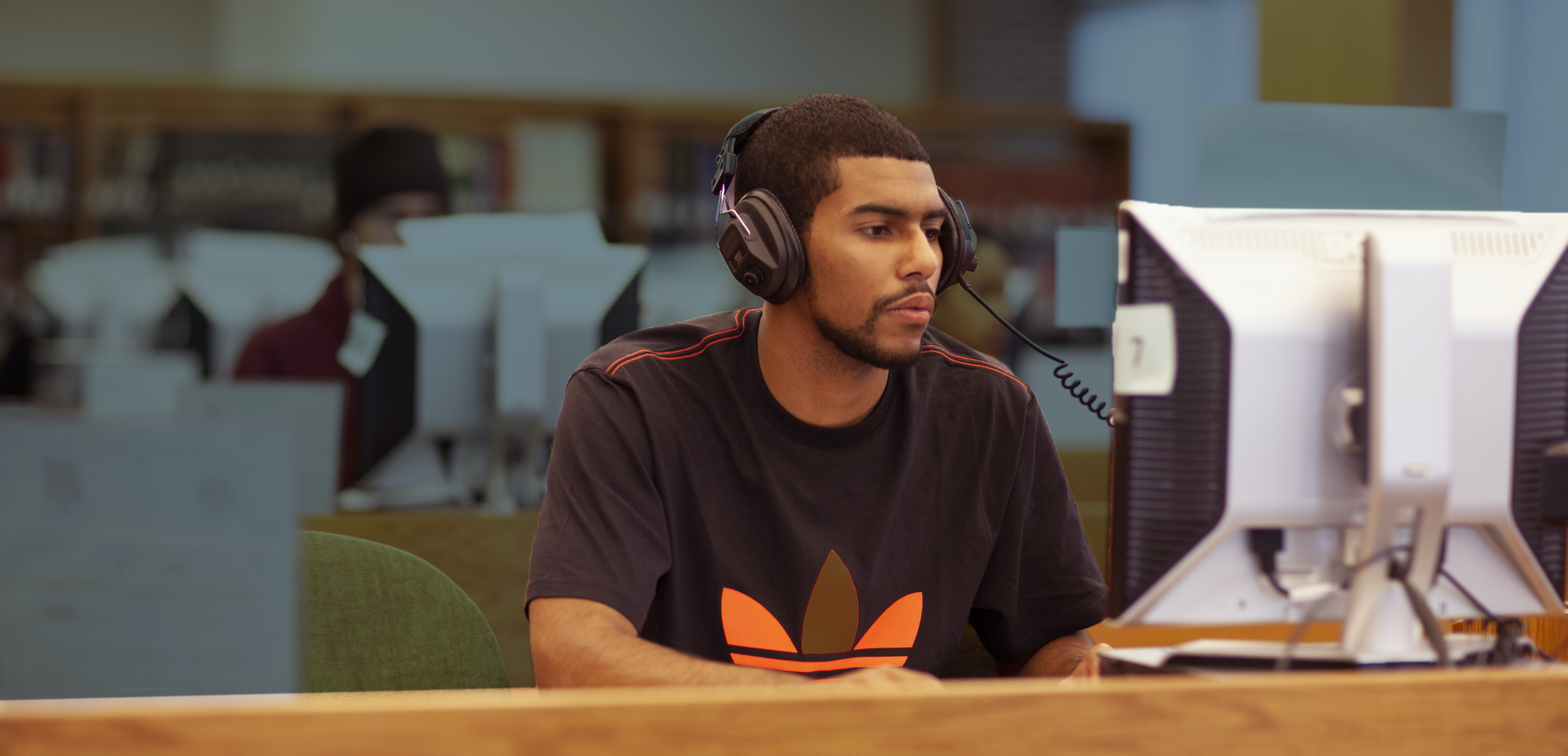 Student wearing headphones using a computer on campus.